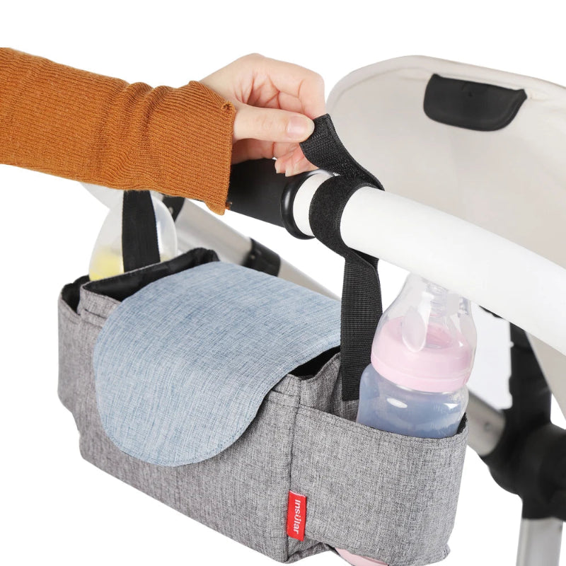 Gray stroller organizer with a bottle and napkin holder attached to a stroller, featuring the brand 'Insular'.