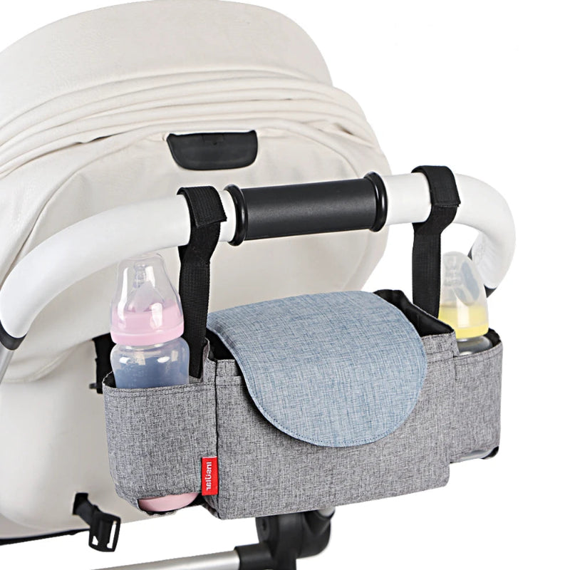 Gray stroller organizer with bottles attached to a white stroller, featuring the brand 'Insular'.