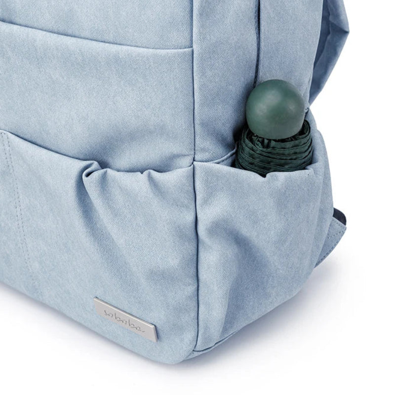 Light blue backpack with a water bottle in a pocket on a white background