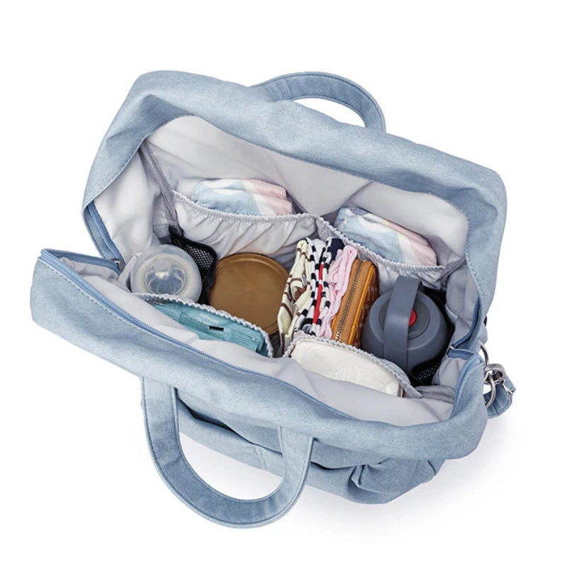 Blue travel bag with various items inside on a white background