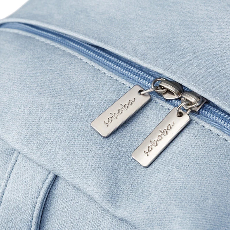 Light blue backpack with a zipper and visible brand name on a white background