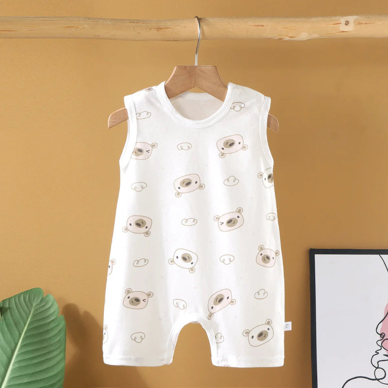 White baby romper with bear pattern on a hanger against a yellow wall.