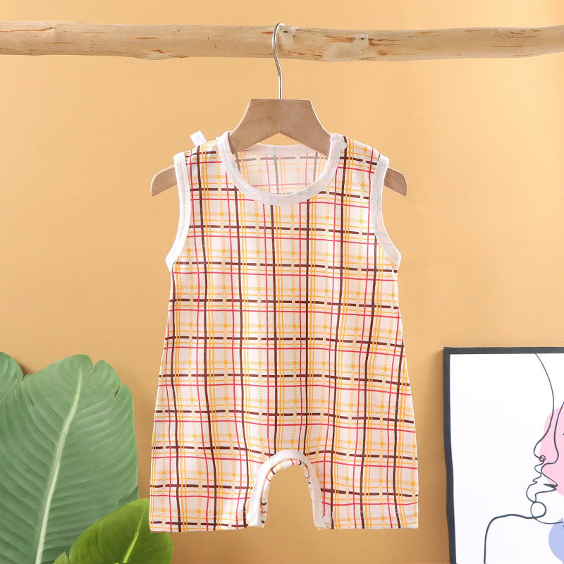 Plaid baby romper on a hanger against a yellow wall with a plant and framed picture.