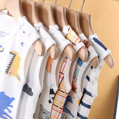 Set of baby vests with colorful patterns on a wooden hanger against a yellow background