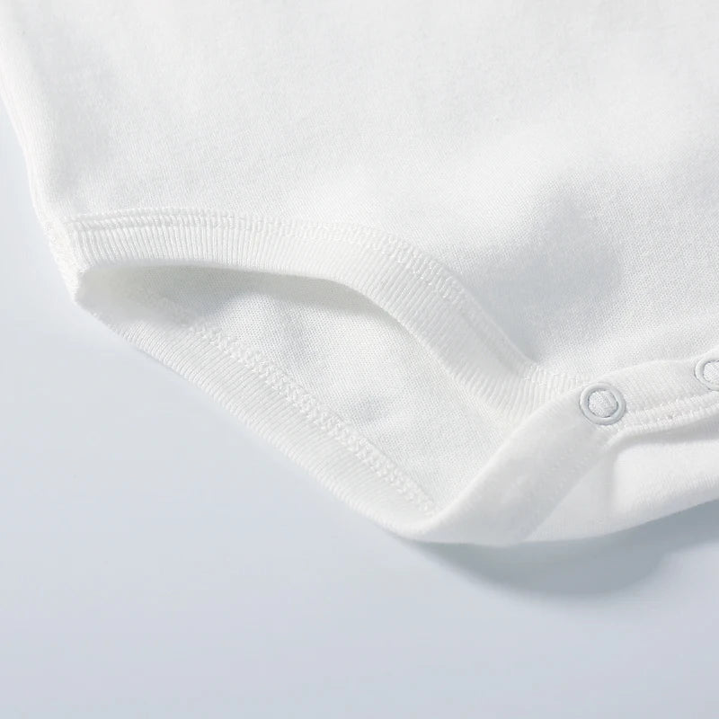 Close-up of a white baby romper on a light gray background