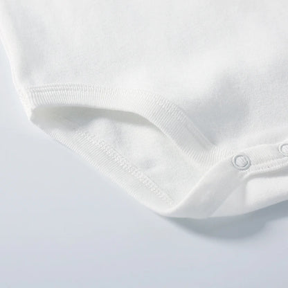 Close-up of a white baby romper on a light gray background