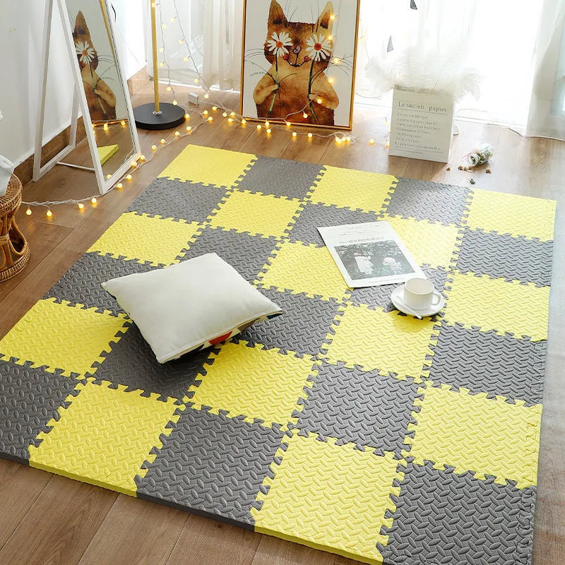 Checkered foam puzzle mat in yellow and gray on a wooden floor with decorative elements.