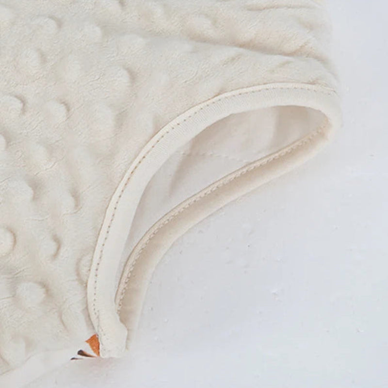 Close-up of a textured beige fabric with a zipper on a white background