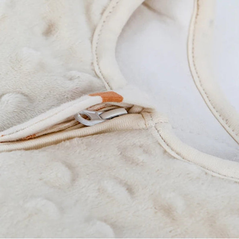 Close-up of a beige fabric with a zipper, likely from a baby carrier or similar product.