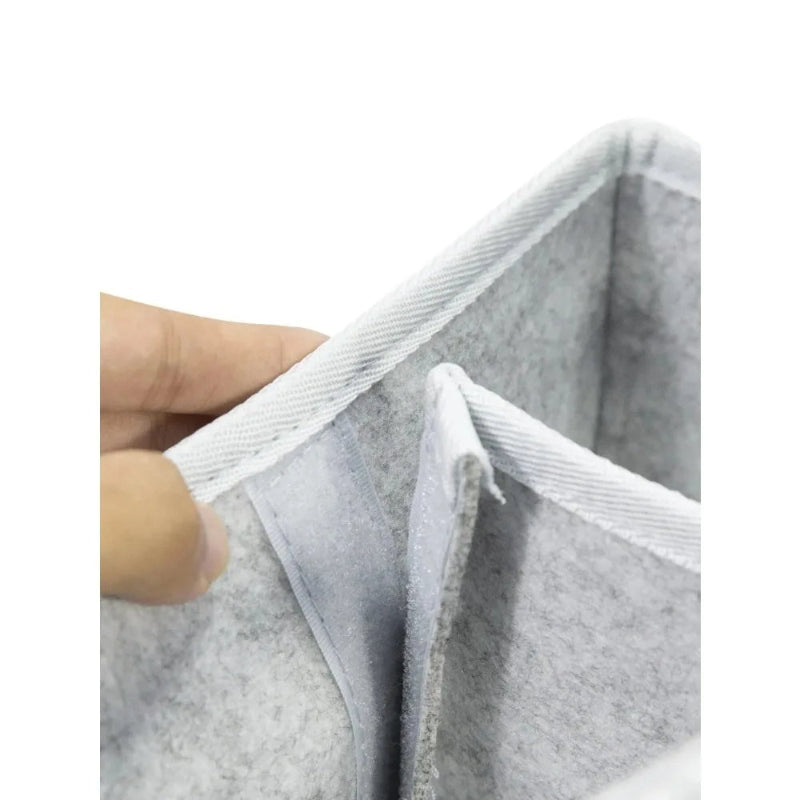 Gray felt material with a hand holding it on a white background