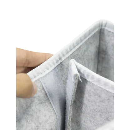 Gray felt material with a hand holding it on a white background